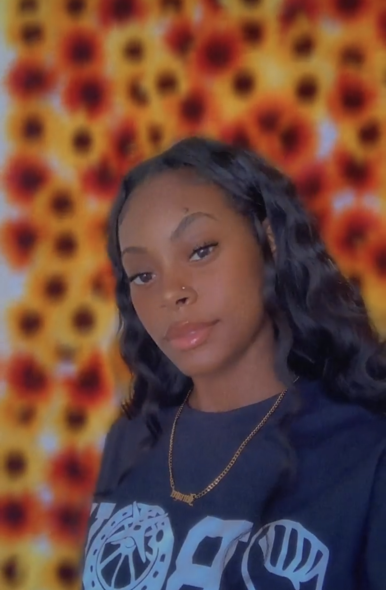 Dark toned woman modeling Black Big Logo tee from ABOY with music playing in background.